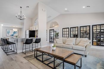 A modern living room with a bar area and a large window.